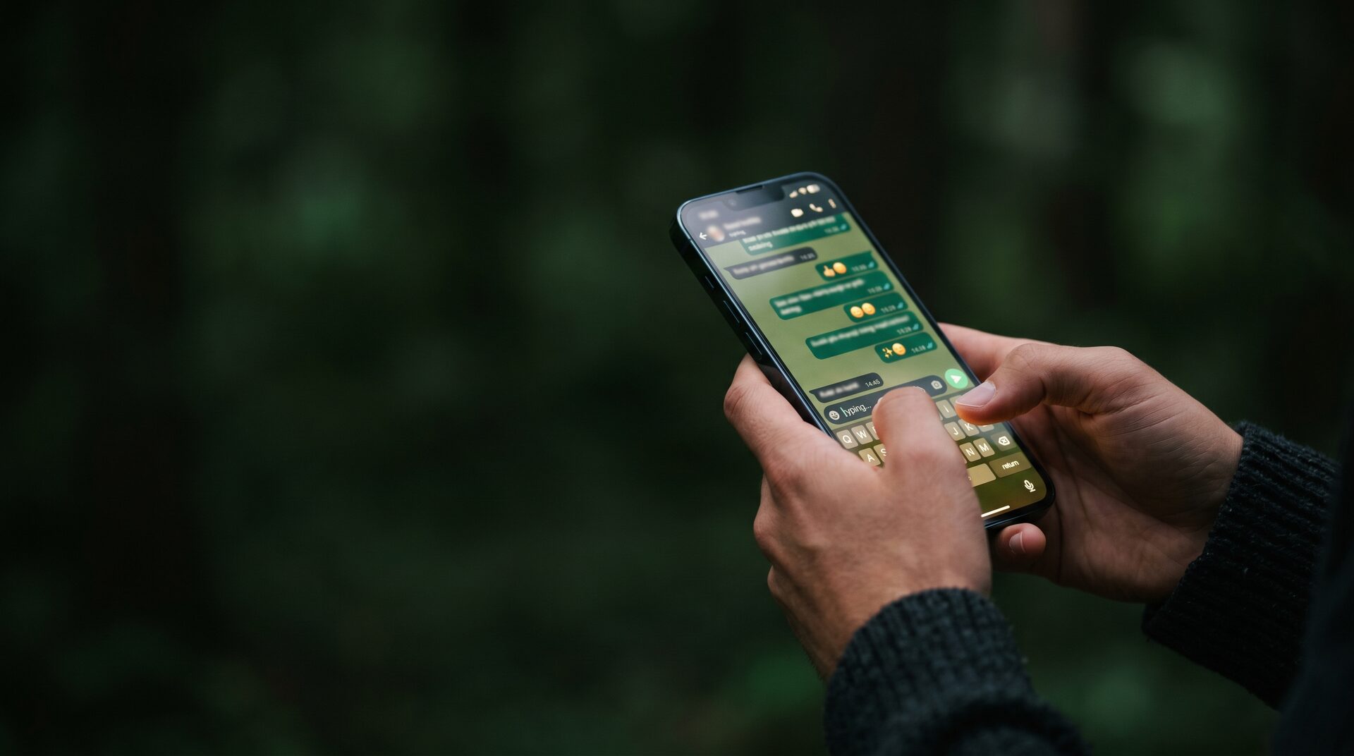 Jemand tippt eine Nachricht im WhatsApp-Kanal auf dem Smartphone